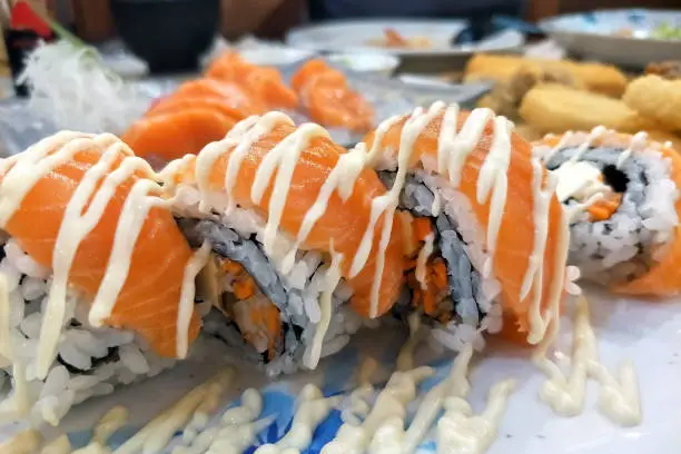 salmon maki sushi roll topped with mayonnaise