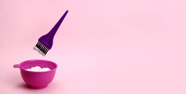 istock brush levitating over a plastic bowl of hair dye 1319003716