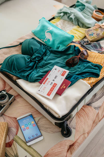 istock Open woman suitcase prepared for summer vacation 1319004943