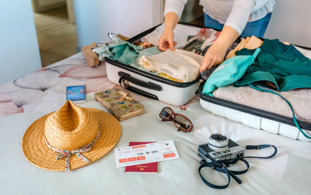 femme méconnaissable préparant la valise pour des vacances d’été - empaqueter photos et images de collection