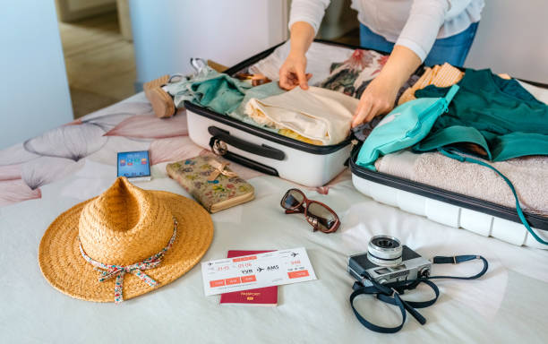 Unrecognizable woman preparing suitcase for summer holidays stock photo