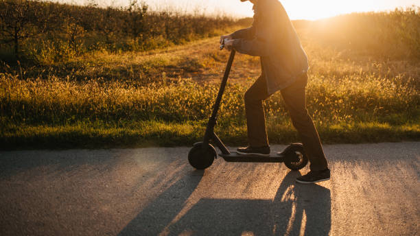 istock Man pushing scooter on the country road 1319004977