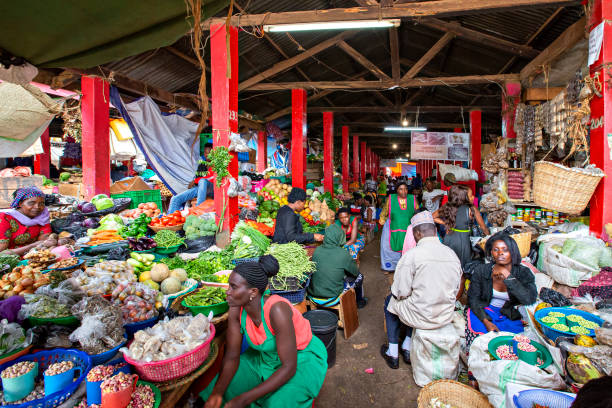 Market in Kampala, Uganda Kampala, Uganda - July 9, 2019: Farmer's market with vendors selling fresh fruits and vegetables in Kampala, Uganda market vendor photos stock pictures, royalty-free photos & images