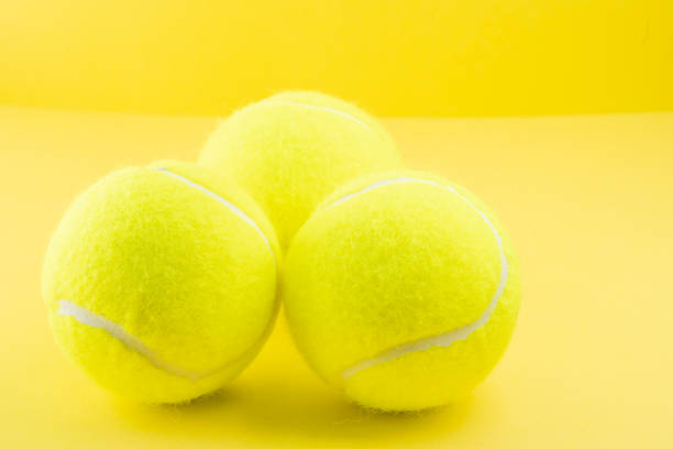 istock Tennis balls on yellow background 1319007408