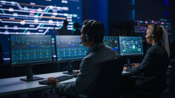 istock Team of Professional Traders Talking into Headsets Work on Computers with Screen Showing Finance Statistics, Charts Strategy, Stock, Telemarketing. Stock Firm Monitoring Room Stock Market Specialists 1319010525