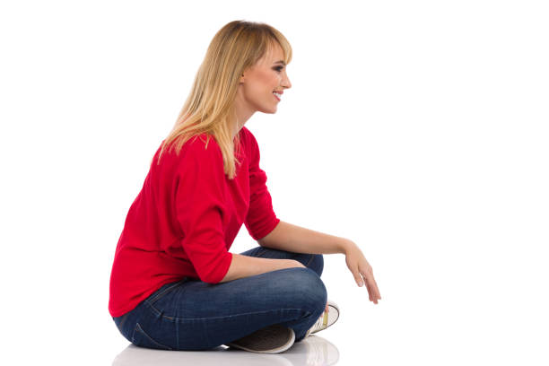 istock Smiling Young Woman In Red Sweater Sits On A Floor. Side View. 1319010603