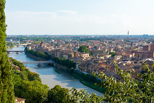 Verona, Veneto/Italy - 18.08.2020: View of the river Adige and its banks in Verona from above with the city of Verona in the background