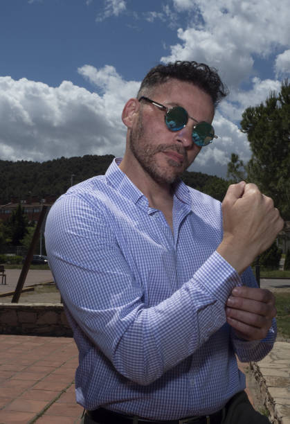 istock Man outdoors with blue sky and clouds in the background, wearing sunglasses. 1319011811