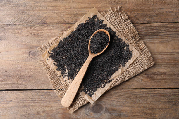 istock Black sesame seeds and spoon on wooden table, flat lay 1319012473