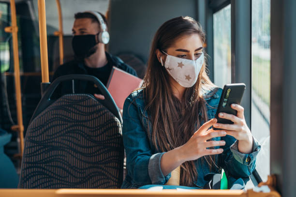 istock Woman wearing protective mask and using a smartphone while riding a bus 1319014658