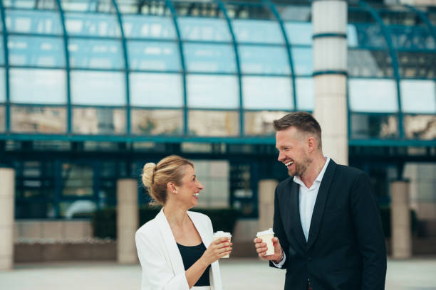 istock Two young businesspeople drinking coffee takeaway 1319014678
