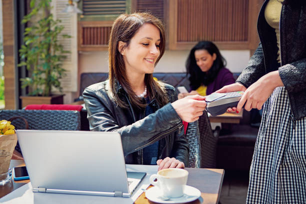 istock Woman is paying using credit card in a cafe 1319014696