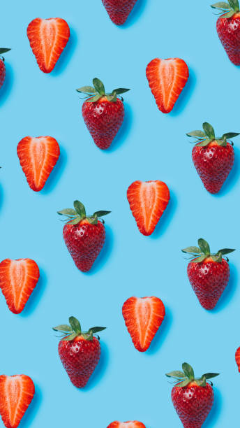 istock Summer food pattern made with fresh strawberries on vibrant blue background. Creative fruit and vegetable texture concept. Healthy vegetarian diet composition. 1319014987