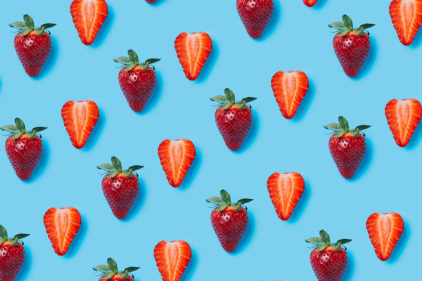 istock Summer food pattern made with fresh strawberries on vibrant blue background. Creative fruit and vegetable texture concept. Healthy vegetarian diet composition. 1319015054