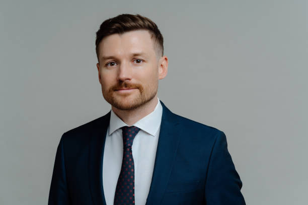 istock Young handsome male executive manager in elegant suit posing against grey background 1319016068