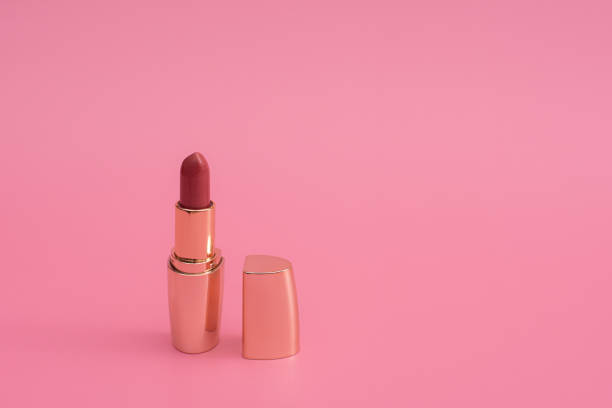 istock red lipstick with lid in gold. on a pink background. copy space 1319016257