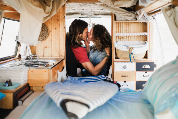 istock Happy boyfriend and girlfriend having tender moment during trip summer vacation inside vintage minivan - Main focus on faces 1319016765