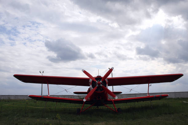 istock Red Civil Biplane On A Grass At Airfield 1319017571