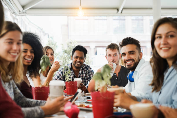 istock Young multiracial people eating brunch and drinking cappuccino at bar restaurant - Focus on center faces 1319019294