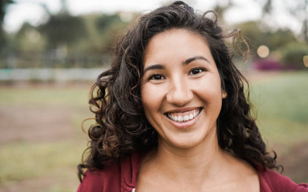 都市公園の屋外カメラで微笑むヒスパニックの女の子 - 顔に焦点を当てる - nature curly hair smiling human face ストックフォトと画像