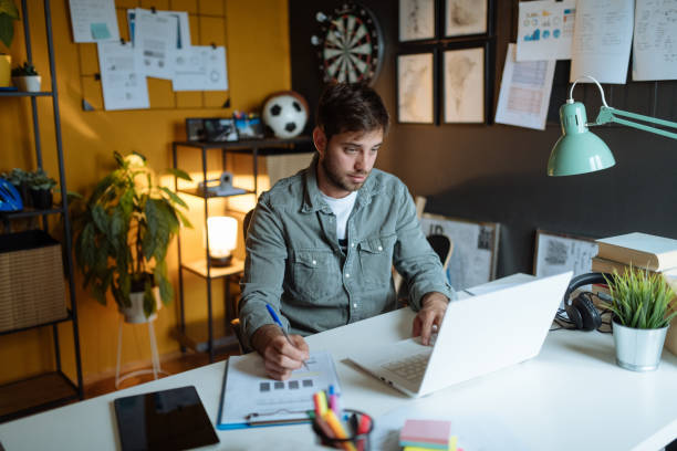 istock Millennial man working in modern office on laptop 1319021968