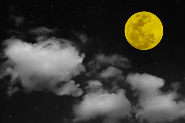 Yellow full moon and white clouds on the sky.
