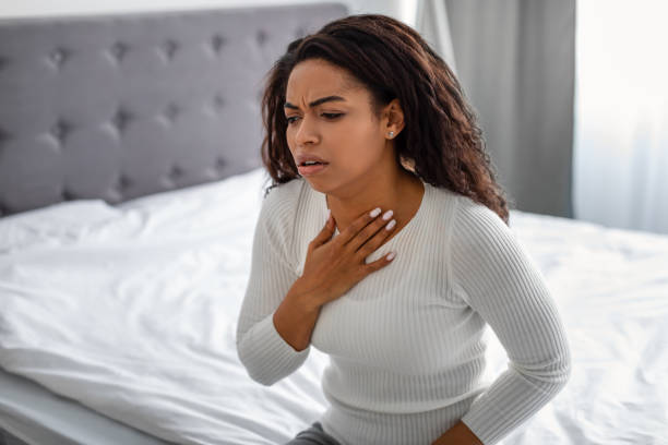 istock Young black woman coughing, suffering from sore throat 1319025702