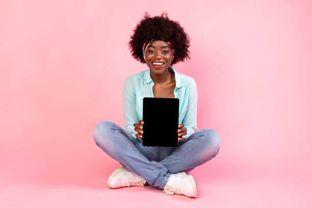 istock Cheerful African American Lady Showing Digital Tablet Empty Screen, Pink Background 1319025884