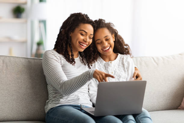 istock Excited african american mother and kid using laptop together 1319025934
