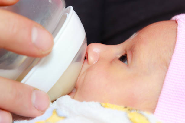 istock Little newborn baby lying, drinking from bottle 1319025940