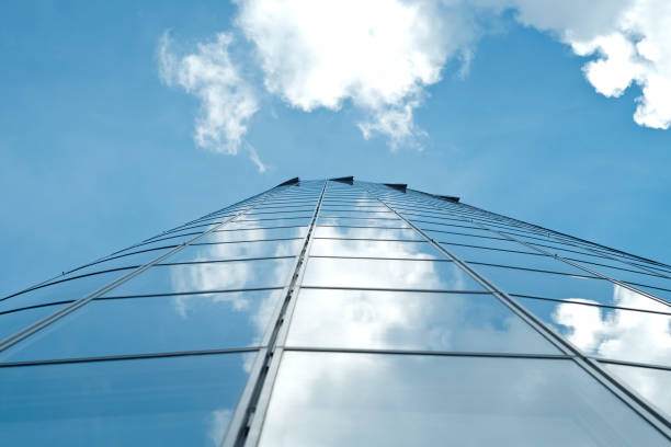 istock Facade of modern skyscraper with reflection of cloudy sky, low angle shot, free copy space 1319027391