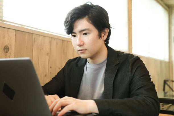 istock Portrait of Young Man using laptop at cafe 1319029255