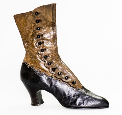 a single antique ladies leather boot in two shades of brown with a high heal and buttons