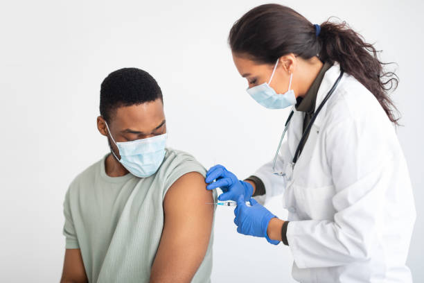 istock General Practitioner Vaccinating African American Male Patient Over White Background 1319029547