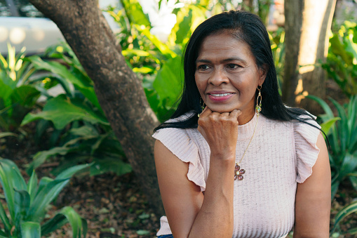 Portrait of a smiling middle-aged African-American woman sitting in the park.