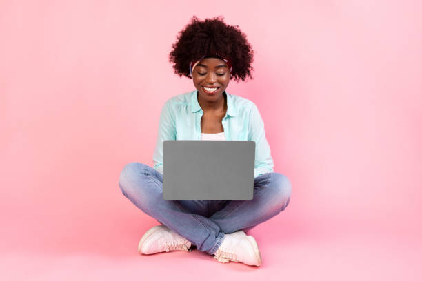 istock African American Female Using Laptop Working Online Browsing Internet, Pink Background 1319030335