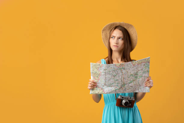 istock Concentrated young woman with camera holding city map 1319030456
