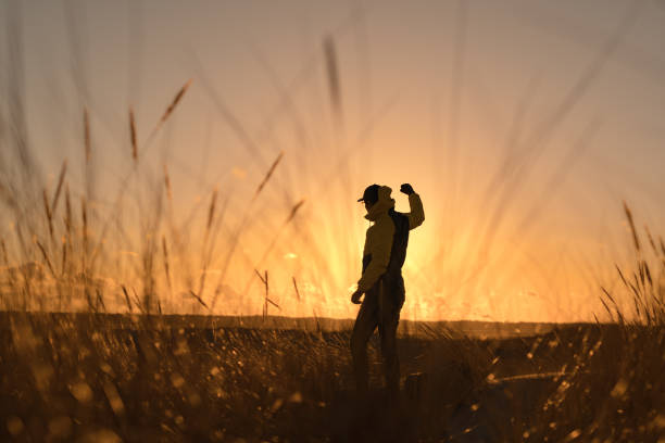 istock Beach relaxation.Young man looking at sea sunset. Standing on the sand dune between reeds 1319031978