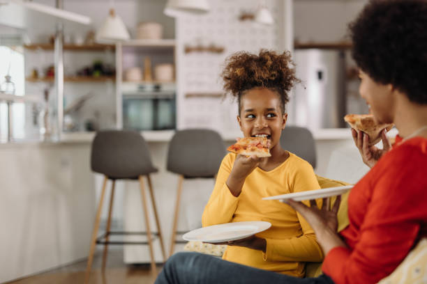 istock Holding a plate and eating slice of pizza. 1319032146