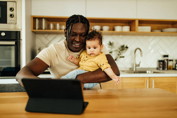 istock Father and baby daughter in the kitchen, looking at tablet. 1319034348
