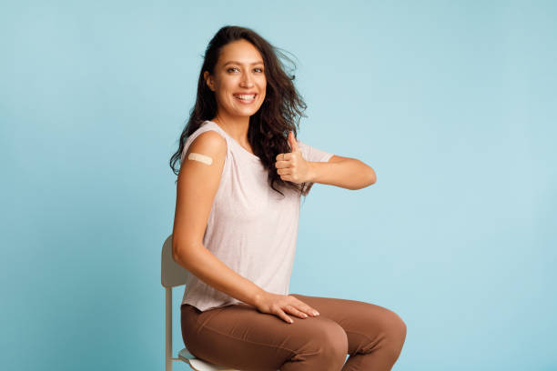 istock Happy Vaccinated Lady Gesturing Thumbs Up After Vaccination, Blue Background 1319039981