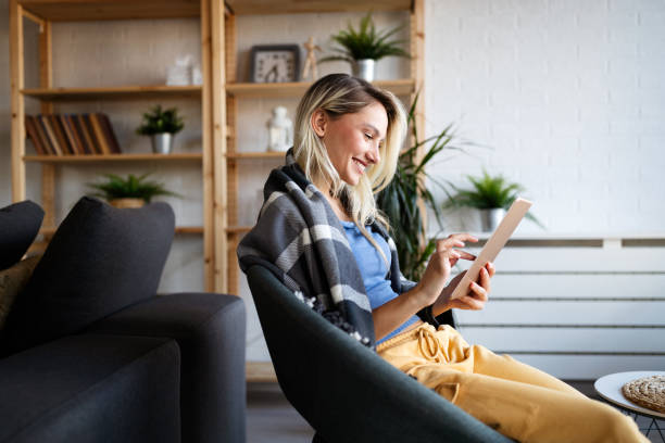 istock Happy young woman using tablet pc in loft apartment 1319040690