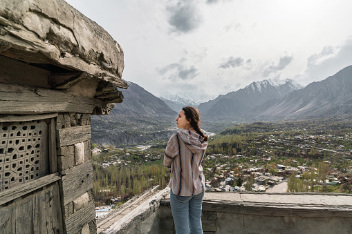 Young Caucasian woman looking out of the balcony in fort