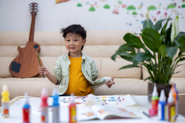 istock Little asian boy drawing at home 1319047265