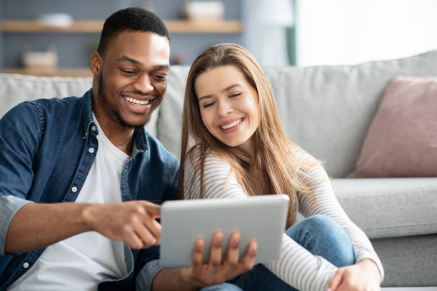 istock Cheerful Multiracial Lovers Using Digital Tablet At Home, Closeup Shot 1319048847
