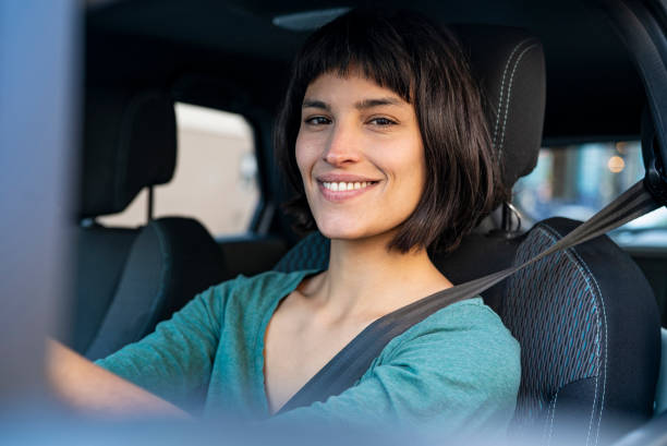 istock Cheerful woman with hands on steering wheel while inside car 1319050111