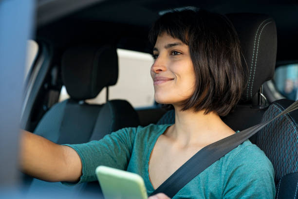 istock Contented woman looking through windshiled while holding mobile phone 1319050138