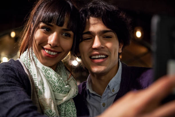 istock Happy friends taking a selfie in bar at night 1319050158
