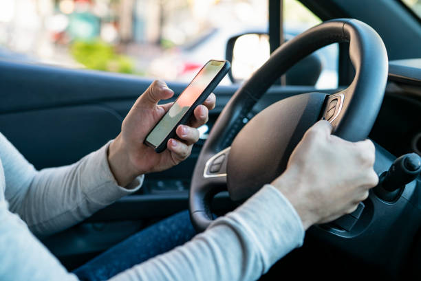 istock Close up of man´s hands holding mobile device inside car 1319050185