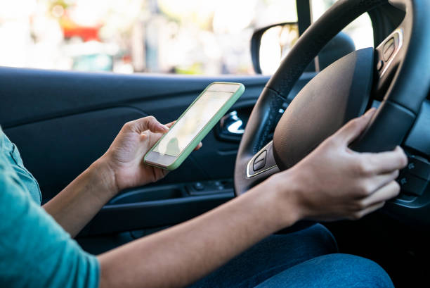 istock Close up of woman´s hands holding mobile device while driving 1319050260